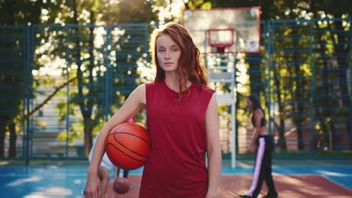 A Young Basketball Player on the Court Energetically Engaged with His Team in the Background