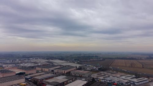 Panoramic aerial footage showing a large industrial park with factories and warehouses on a gloomy,