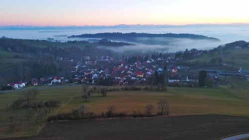 Highways Pass Through Valley with Forests Meadows and Village Shrouded in Mist in Evening Light