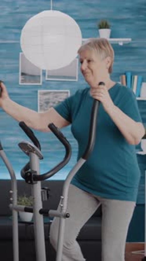 Senior Woman Exercising on Elliptical Machine at Home