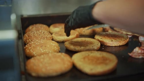 Toasting burger buns on the grill at restaurant