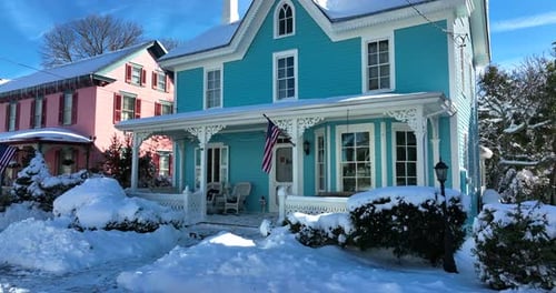 Victorian homes in USA in fresh winter snowfall. Rising aerial pedestal establishing shot. American