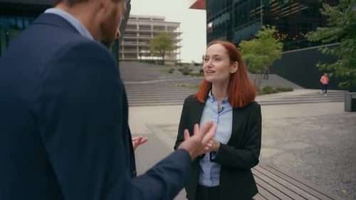 Businesswoman Talking with Colleague in Urban Setting