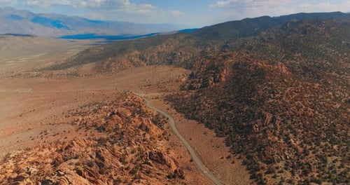 Highway passing among the craggy rocks and deserted landscape. Sunny day footage in the mountains