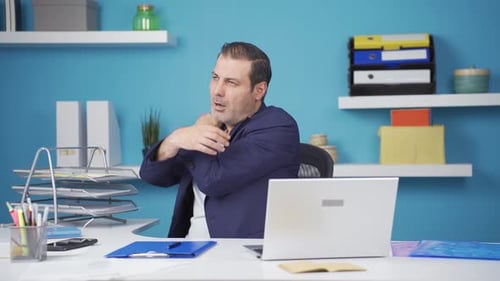 Office Worker Massaging Neck At Desk