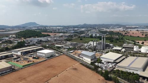 Wide aerial perspective of a sprawling industrial zone, showcasing numerous factories,