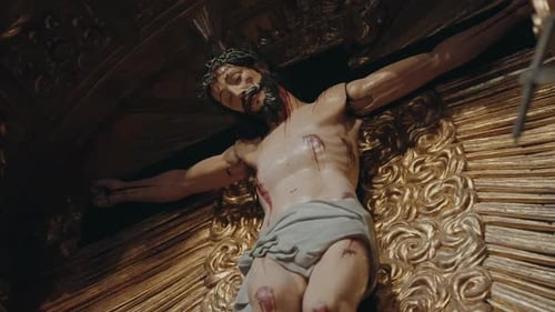 Escultura barroca de crucifixo de Jesus Cristo em altar dourado