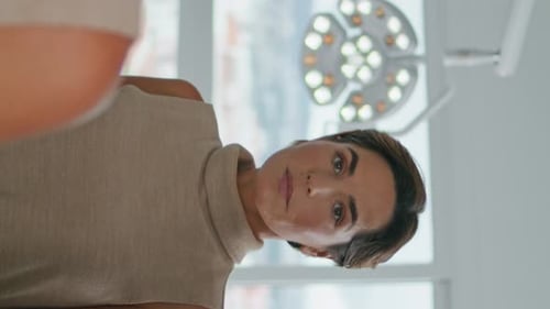 Vertical Portrait Woman Looking Mirror After Procedures in Cosmetology Clinic