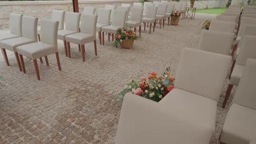 Wedding Ceremony Venue with White Chairs and Flowers
