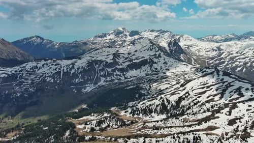 Rocky Mountains in Snow and Green Fir Forest
