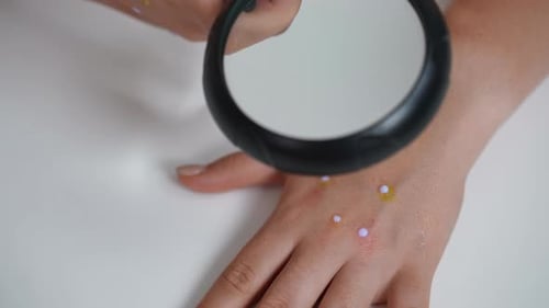 Woman Inspects Hand with Magnifying Glass Close Up