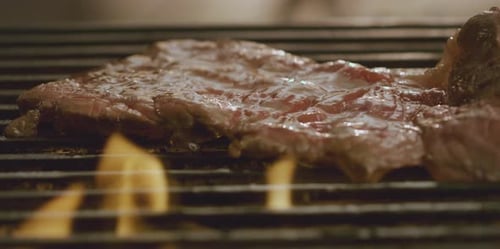 flipping ribeye steaks on grill