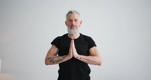 Gray Haired Man Smiling with Hands Clasped