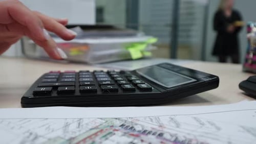 Woman Uses Calculator on City Development Plan