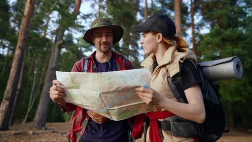 Couple Hiking in a Forest Looking at Map