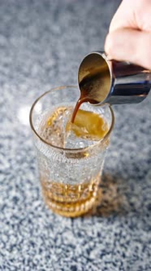 Pouring Coffee into Ice Filled Glass Close Up