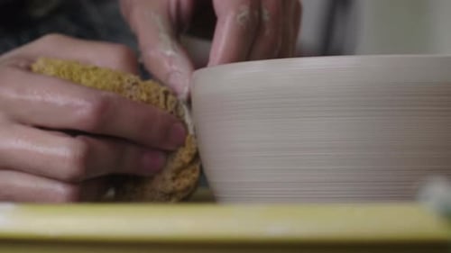 Un potier fabriquant une tasse sur un tour de potier.