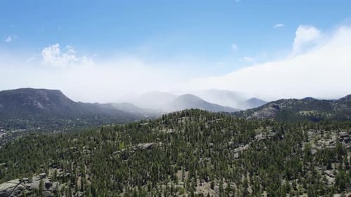 4K Aerial Drone Shot Flying Over Alpine Forest Hill Revealing Epic Mountain Range In The Background