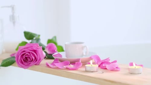 Wunderschöne Spa-Umgebung mit rosafarbener Kerze und Blumen auf Holzuntergrund