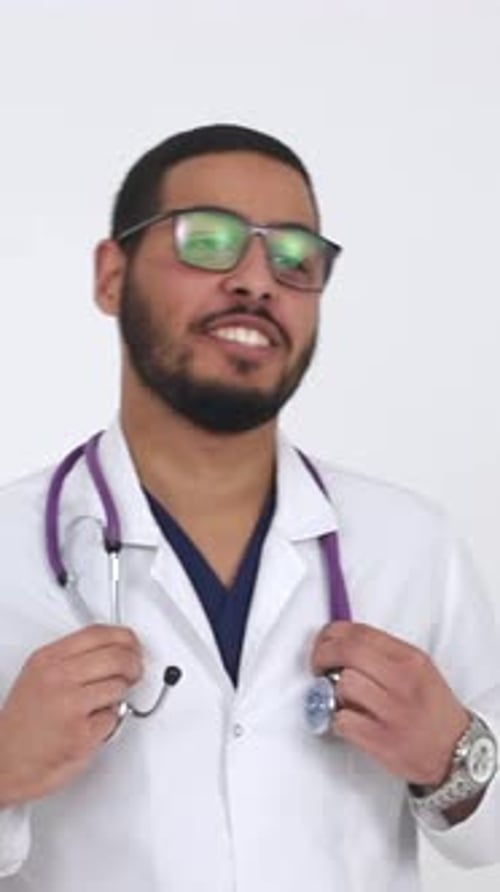 A Cheerful and Smiling Male Doctor Who is Wearing Glasses and a Stethoscope