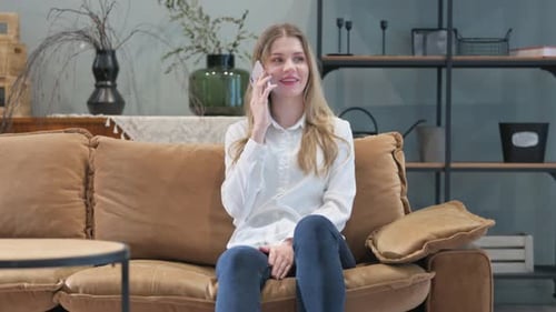 Young Woman Talking on Phone on Couch at Home