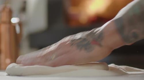 Adult Kneading Dough on Countertop in Kitchen