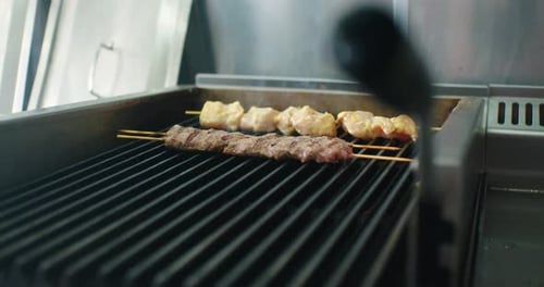 Cooking Meat Skewers on a Metal Grill