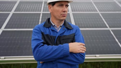 Service Engineer Man Standing with Arms Crossed in Front of Solar Panels Technician Maintenance