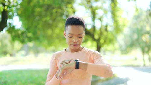 Woman Uses Smart Watch in Green Park