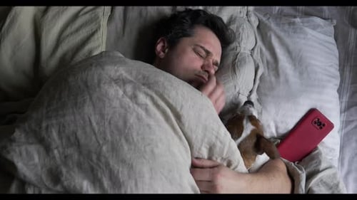 Adult and Dog Sleeping in Bed at Home