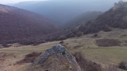 Hiking father and daughter wondering on a cliff in the nature. Aerial slow motion view