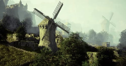 Windmills and Ancient Castle in Misty Hillside Landscape at Dawn