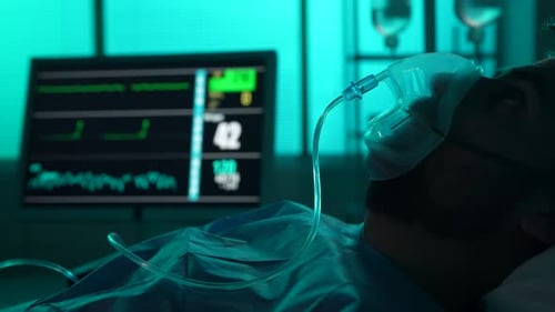 Closeup Detail Video of a Patient on Breathing Support Dying in a Hospital Bed His ICU Monitor on