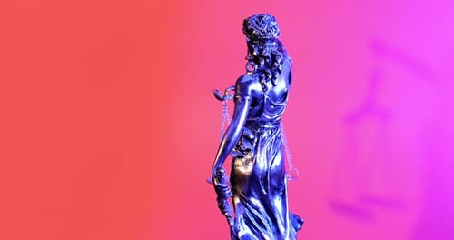 Lady Justice Statue Against Pink and Orange Backdrop