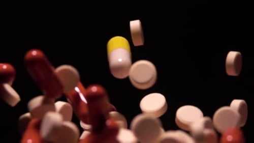 Various Pills Fall on a Black Background in Slow Motion 1000 Fps