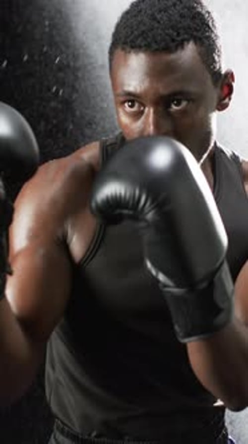 Young adult with boxing gloves training