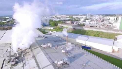 Drone aérien filmé dans un environnement de smog industriel et industriel avec une ville à l'horizon