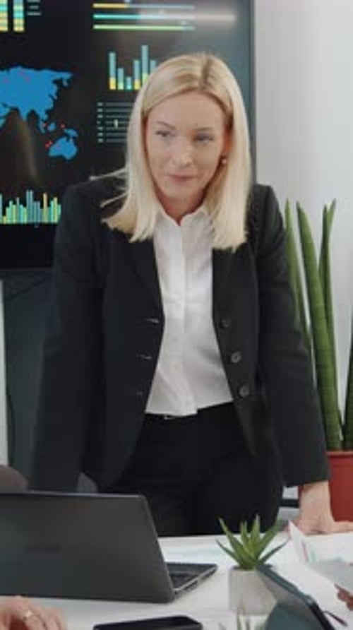 Businesswoman Discussing Data with Team in Modern Office