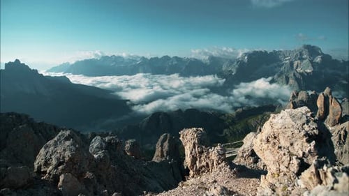 Timelapse of a mountain surrounded valley with moving clouds.
