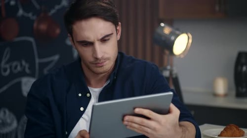 Young Man Using Tablet Device Indoors