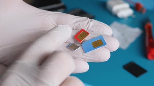 Repairman's Hand Hold Hold Different Types and Sizes of SIM Cards