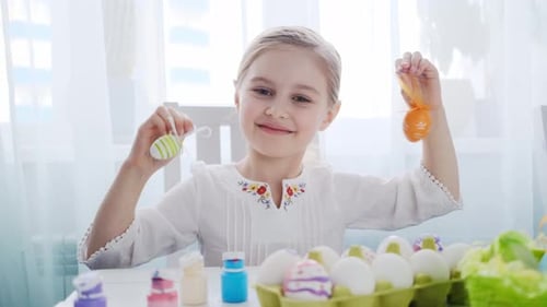 Das Kind zeigt ihre Osterdekorationen