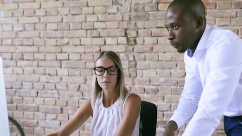 Two Business People In The Office Working Together.
