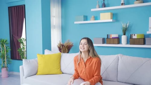 Cheerful Woman Dancing and Relaxing on Couch