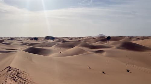 Pan across golden desert sand dunes under sunny sky with copy space