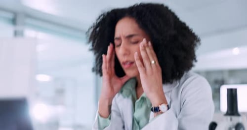 Woman with Curly Hair Typing, Rubs Temples