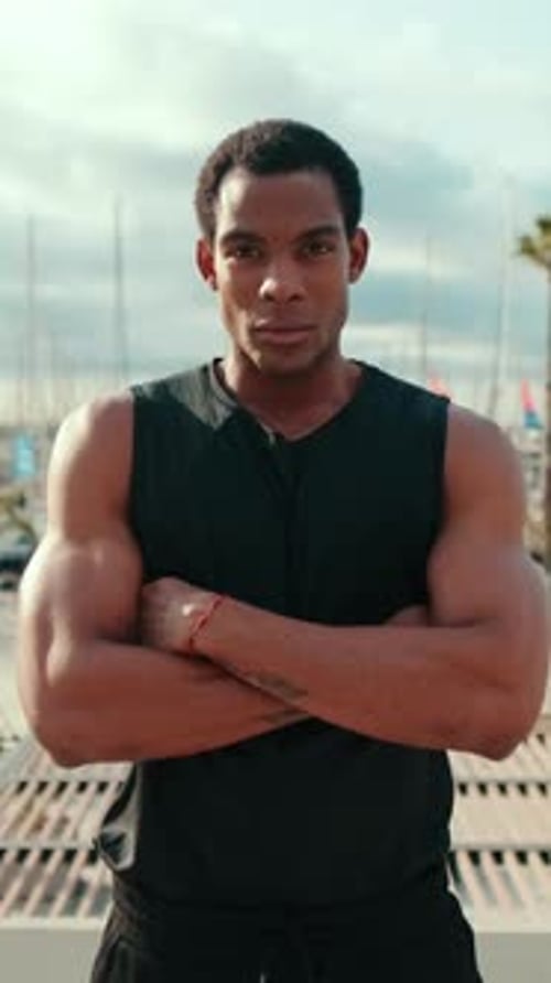Vertical video, Confident Black Athlete at Harbor with Crossed Arms