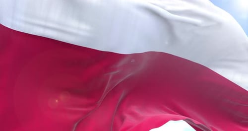 Polish Flag Waving Against Blue Sky