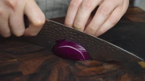 Hands Carefully Slice Red Onion With Sharp Knife