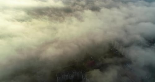 Aerial view of the city covered in fog at sunrise